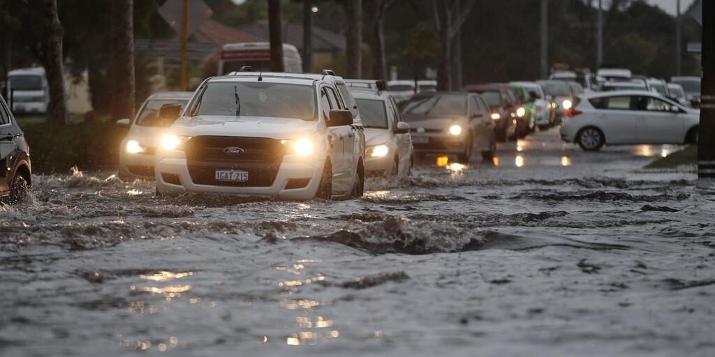 Cars drive through floodwaters on Pearson Street, Churchlands. Some cars did not make it through and had to be towed - others mounted the kerb and drove along the grass beside the road as to avoid the floodwaters. 9 JULY 2021 Picture: Danella Bevis The West Australian